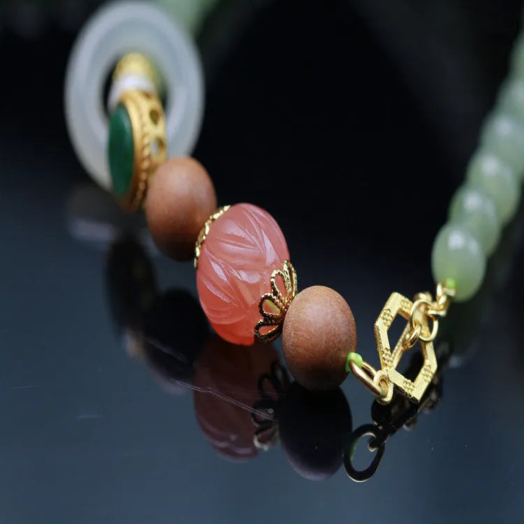 Hand-carved red Hetian Jade lotus bead necklace with white sandalwood beads, beeswax pendant, and zodiac charm.