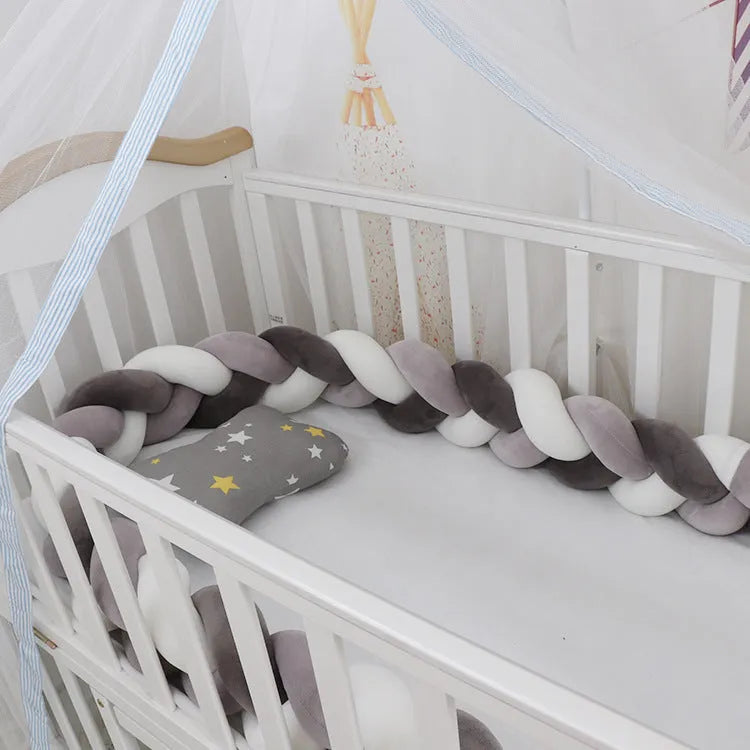 Bendable braid knot baby crib bumper in spandex velvet fabric on a white cot.