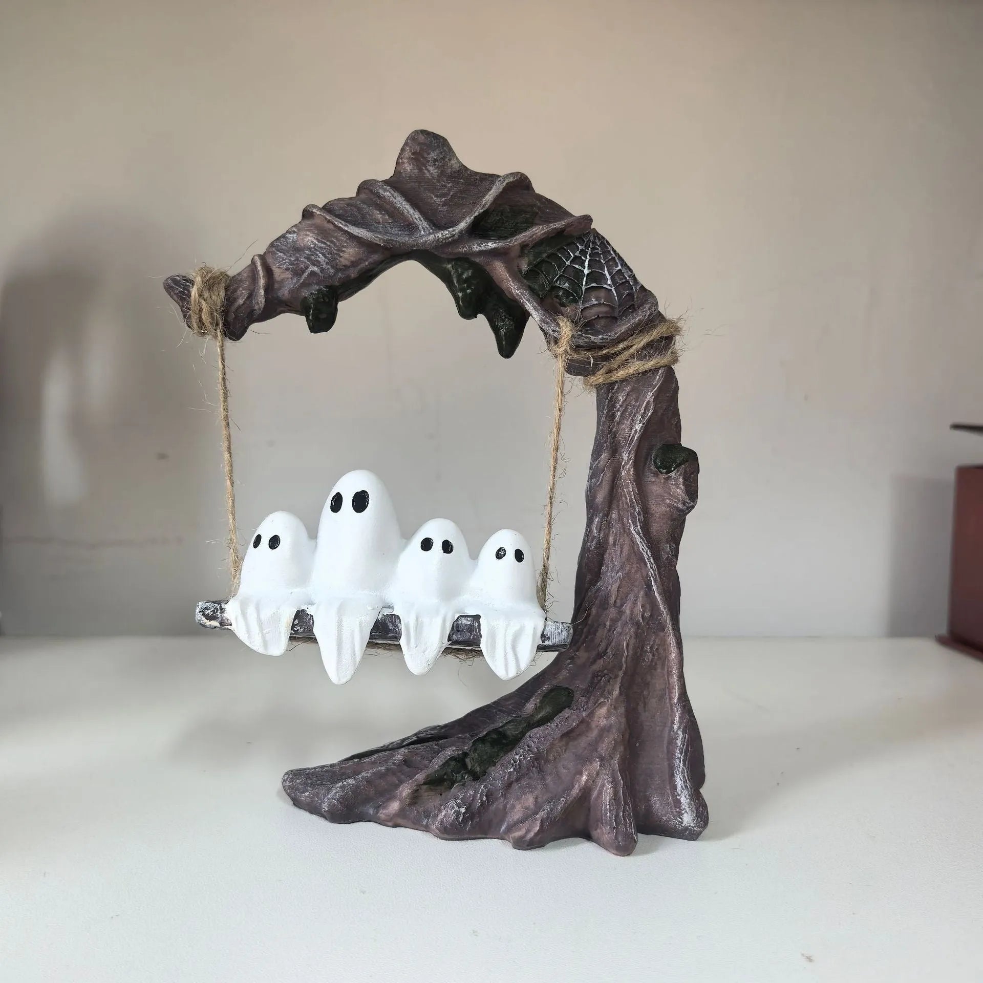 Grey resin Halloween ghost swing ornament with modern art design on display