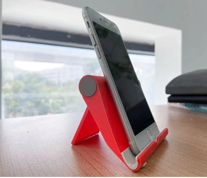 A black PE plastic folding stand holding a mobile phone at an angle.