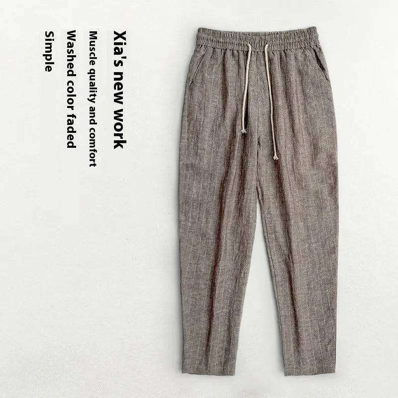 Man wearing beige striped cropped casual cotton-linen trousers on a summer day.