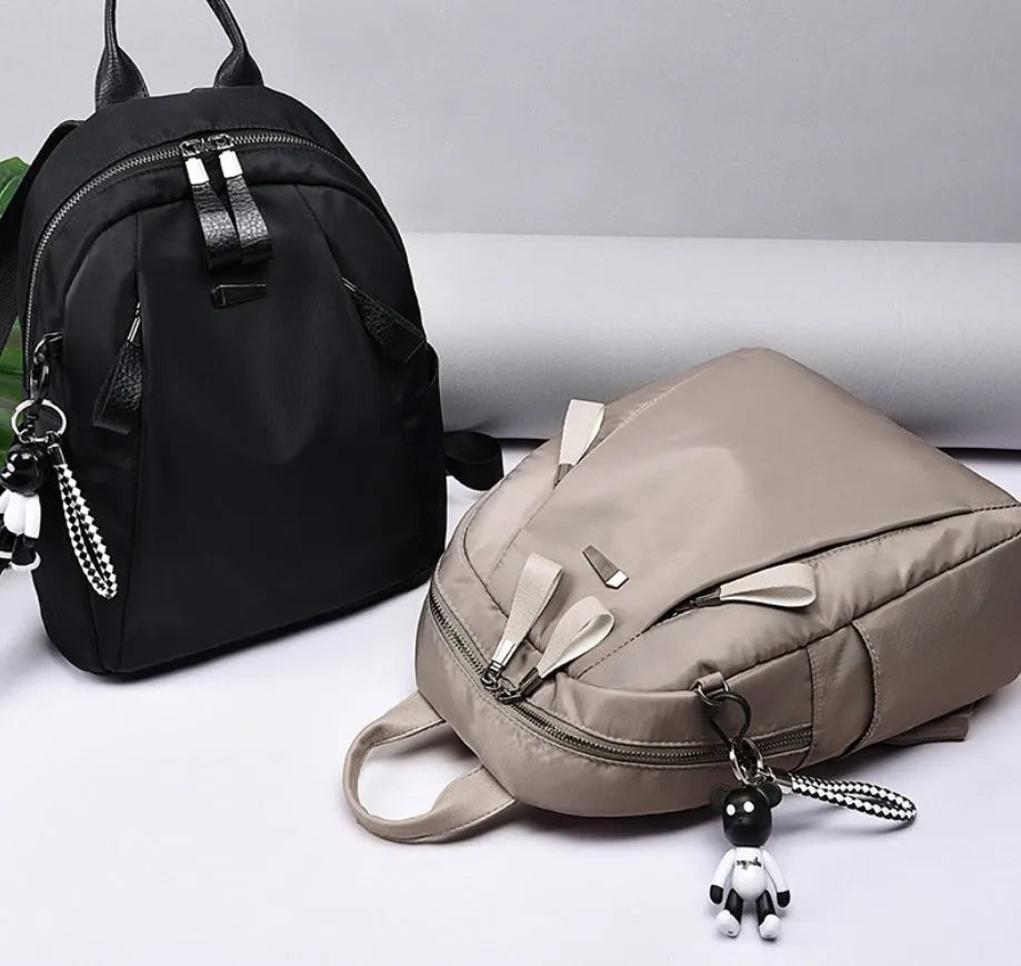 Medium square-shaped Oxford cloth rucksack in grey with double straps and a soft handle.