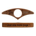 Handmade wooden thumb bookmark ring in beech wood with antique-style finish on an open book