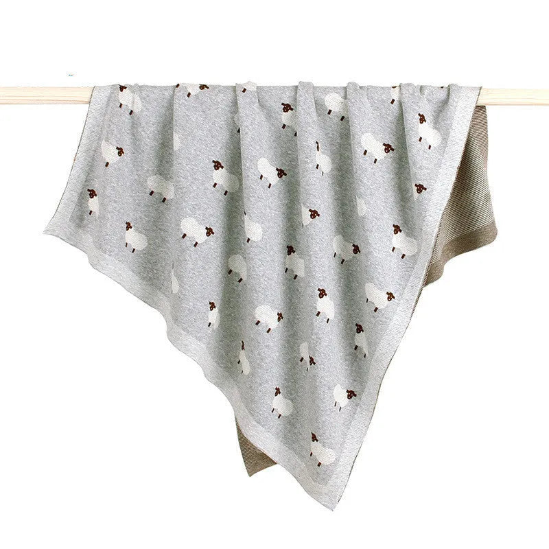 A pink baby sheepskin blanket measuring 100 by 80 cm on a pram.