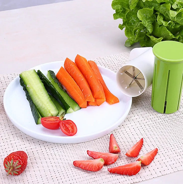 White plastic vegetable and fruit slicer with multiple stainless steel blades for cutting cucumbers, carrots, and strawberries.