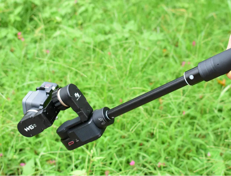 Black retractable selfie stick extended to full length with phone attached, showing detachable tripod legs and wireless remote.