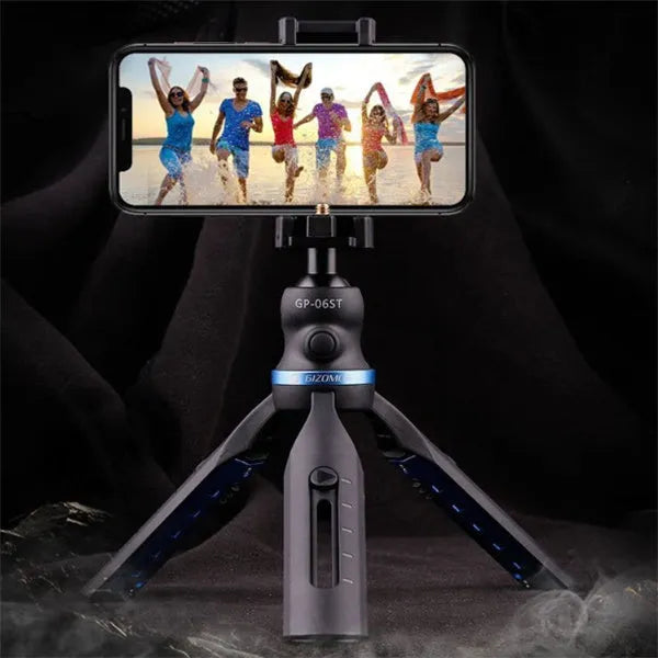 Black desktop tripod holding an iPhone, made from aluminium alloy and plastic, on a wooden table.