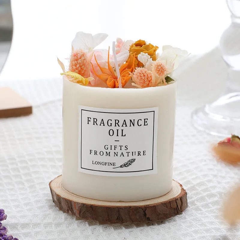 Decorative aromatherapy candle with dried flowers on surface, shown in gift box with chip base.