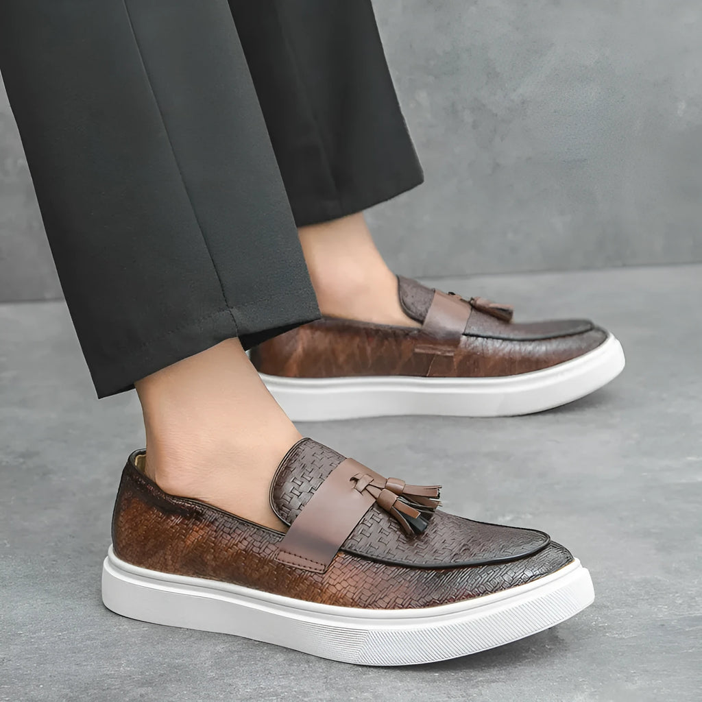 Men's black casual leather shoes with fringe detail on round toe, low heel.