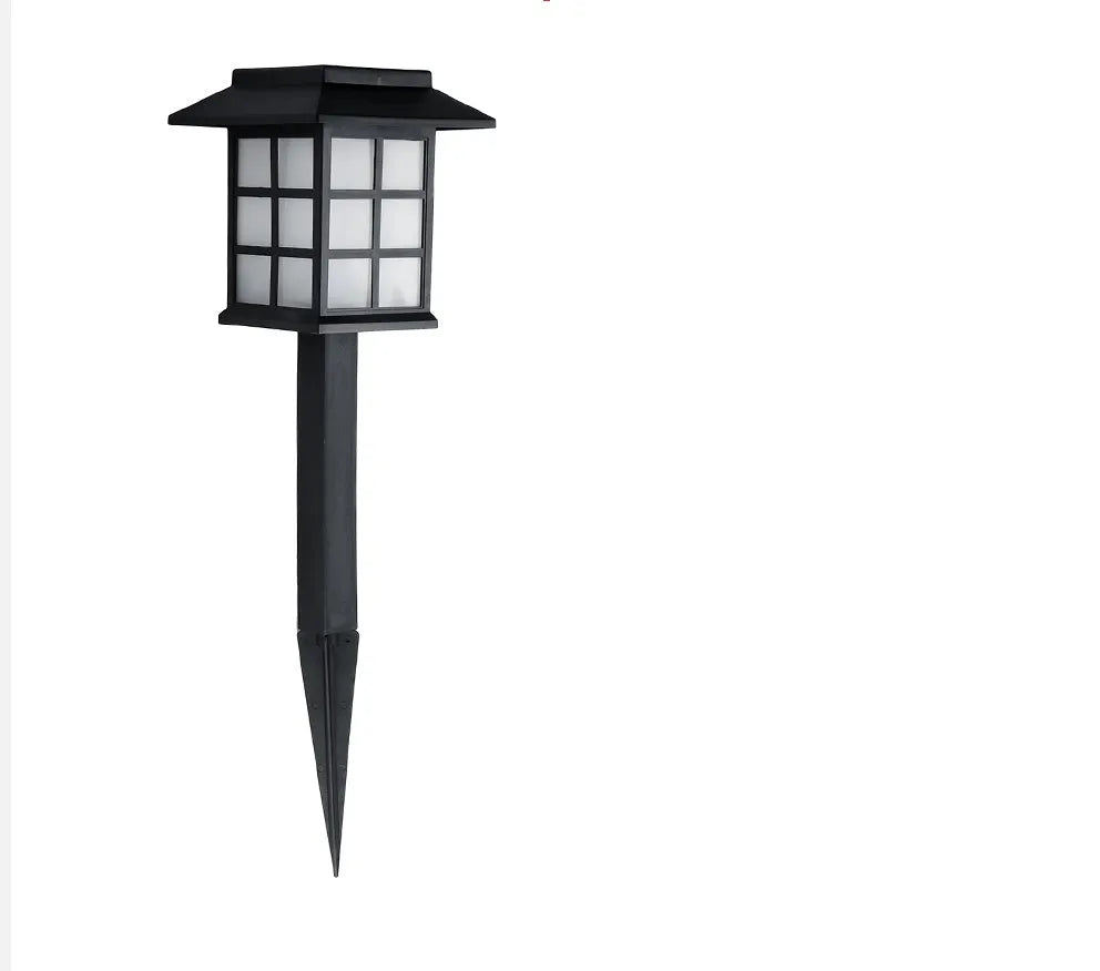 Black solar outdoor LED lawn light with window-style apertures emitting soft white or warm white light