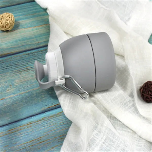 Blue silicone folding water bottle shown both fully expanded and folded to half its height