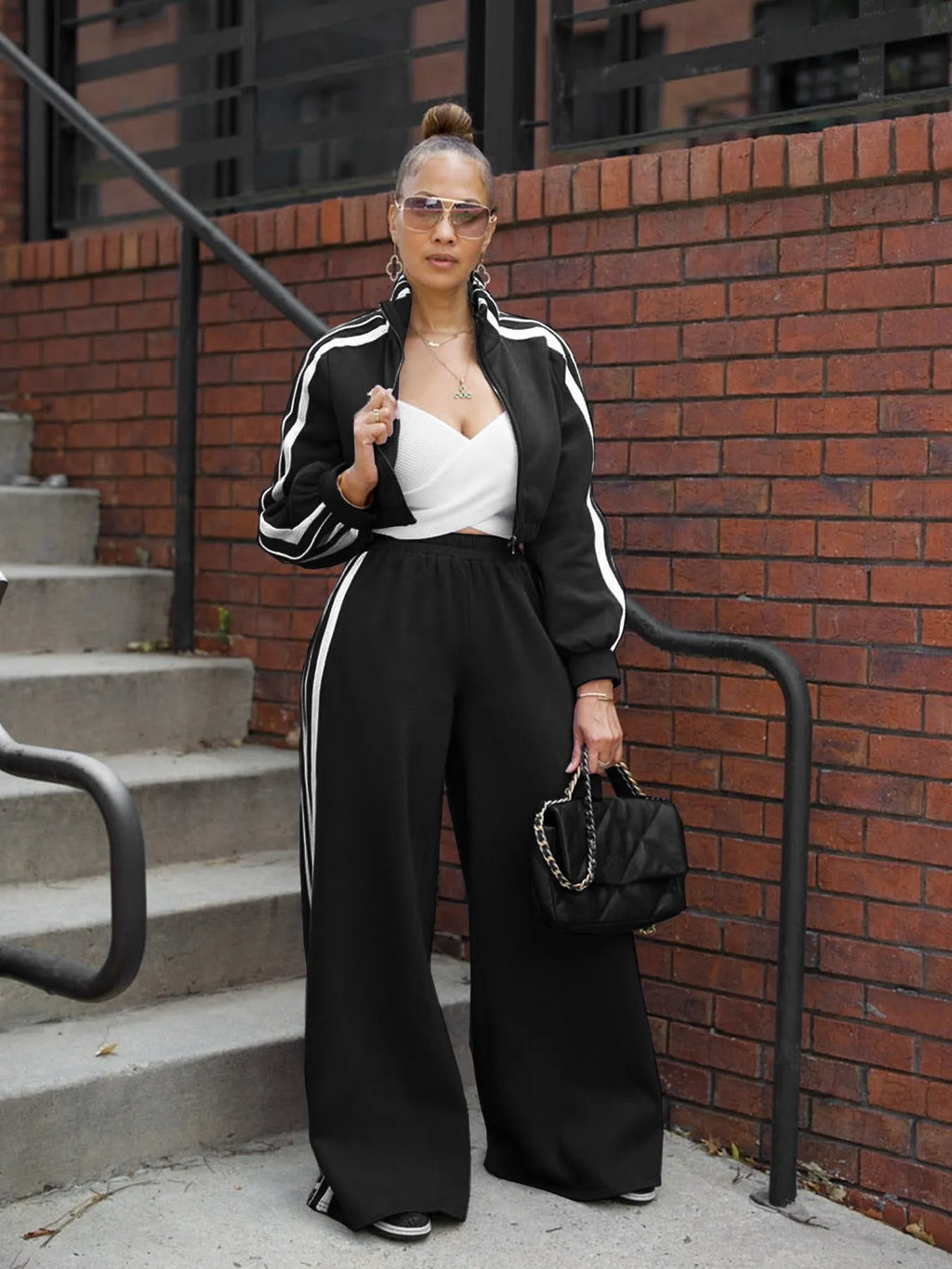 A striped grey two-piece tracksuit set with a zipper top and trousers on a mannequin.