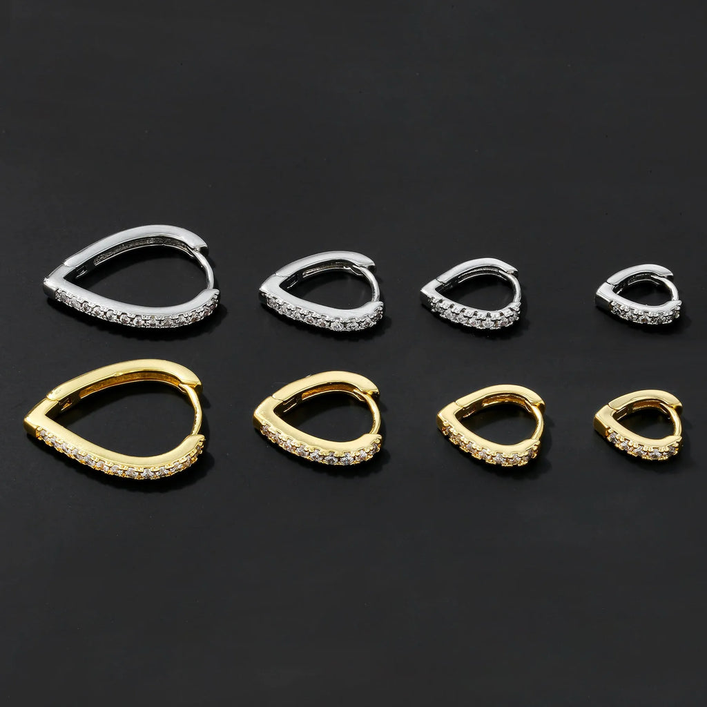 Geometric gold-coloured heart-shaped ear clip on a white background.