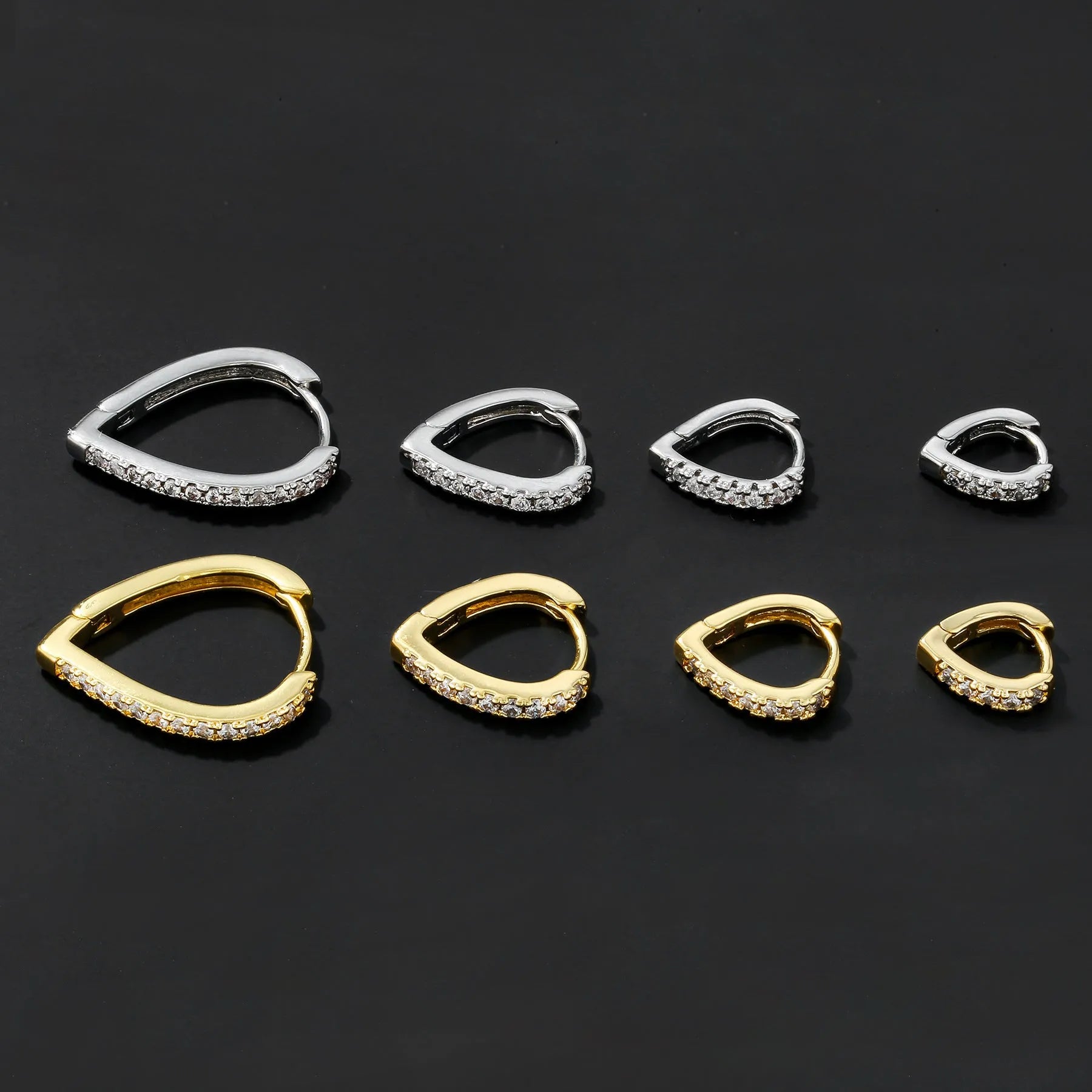 Geometric gold-coloured heart-shaped ear clip on a white background.