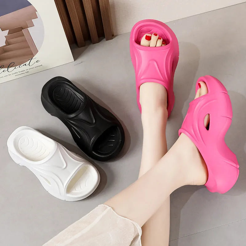 Women's white thick-sole EVA beach slippers with a round toe, shown on a sandy background.