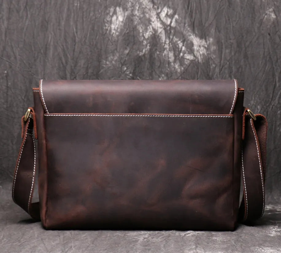 Vintage brown cowhide men's messenger bag showing front flap and adjustable shoulder strap