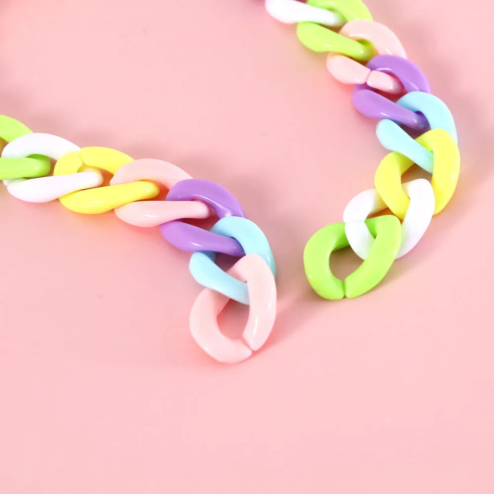 A plastic pet collar in macaron candy colours shown in blue, pink, and mixed variants, with a chain design and S/M size tags.