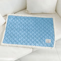 Quilted blue terry cloth pet blanket for cats shown on a pet bed.