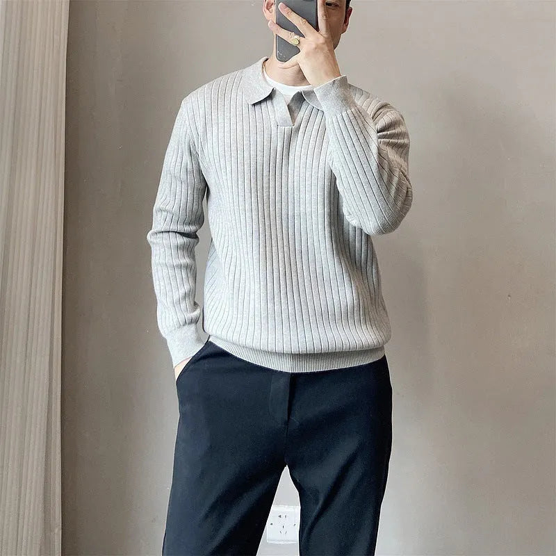 Man wearing a loose striped knitted sweater with a lapel collar in light grey.
