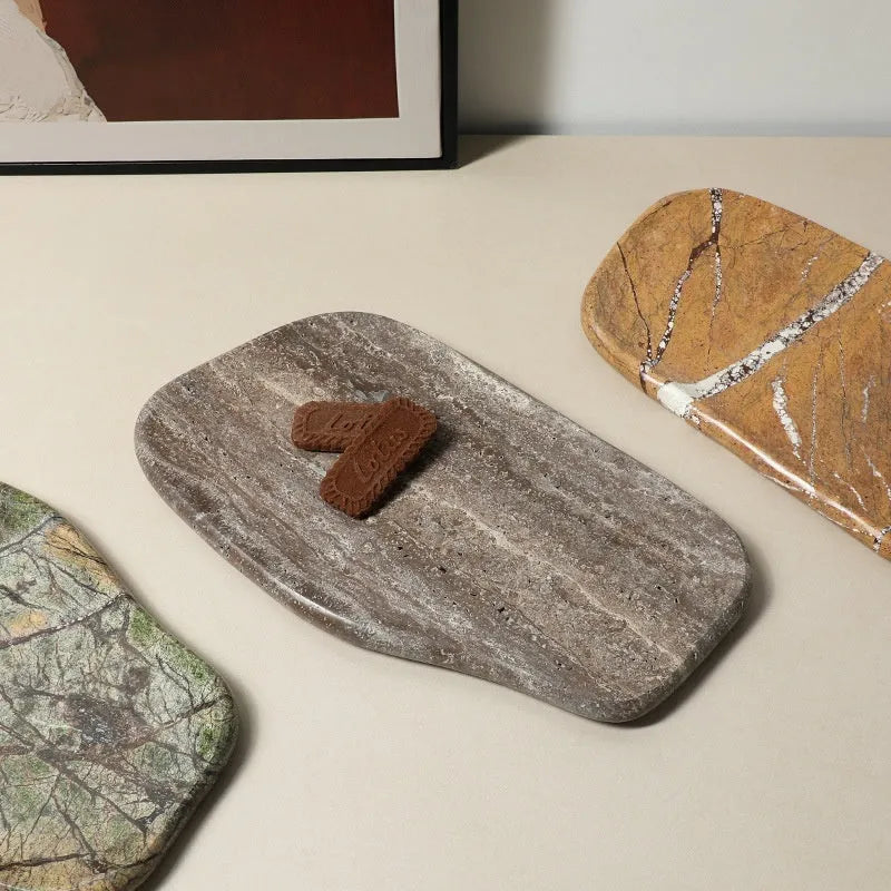 Irregular art marble tray in coffee colour on a wooden table with a plant