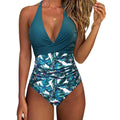 Female model wearing a printed one-piece bikini swimsuit with a lace-up backless design.