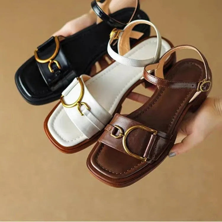 Women's black round-toe sandals with thick rubber sole and button fastening.