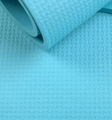 Red EVA fitness yoga mat with rolled edge showing thickness, alongside a blue mat and OPP storage bag.