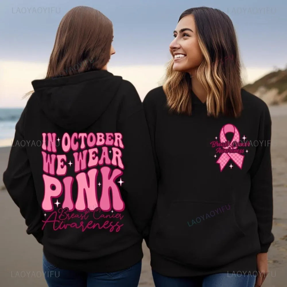 Pink breast cancer awareness hoodie with retro pattern and side pocket on a hanger.