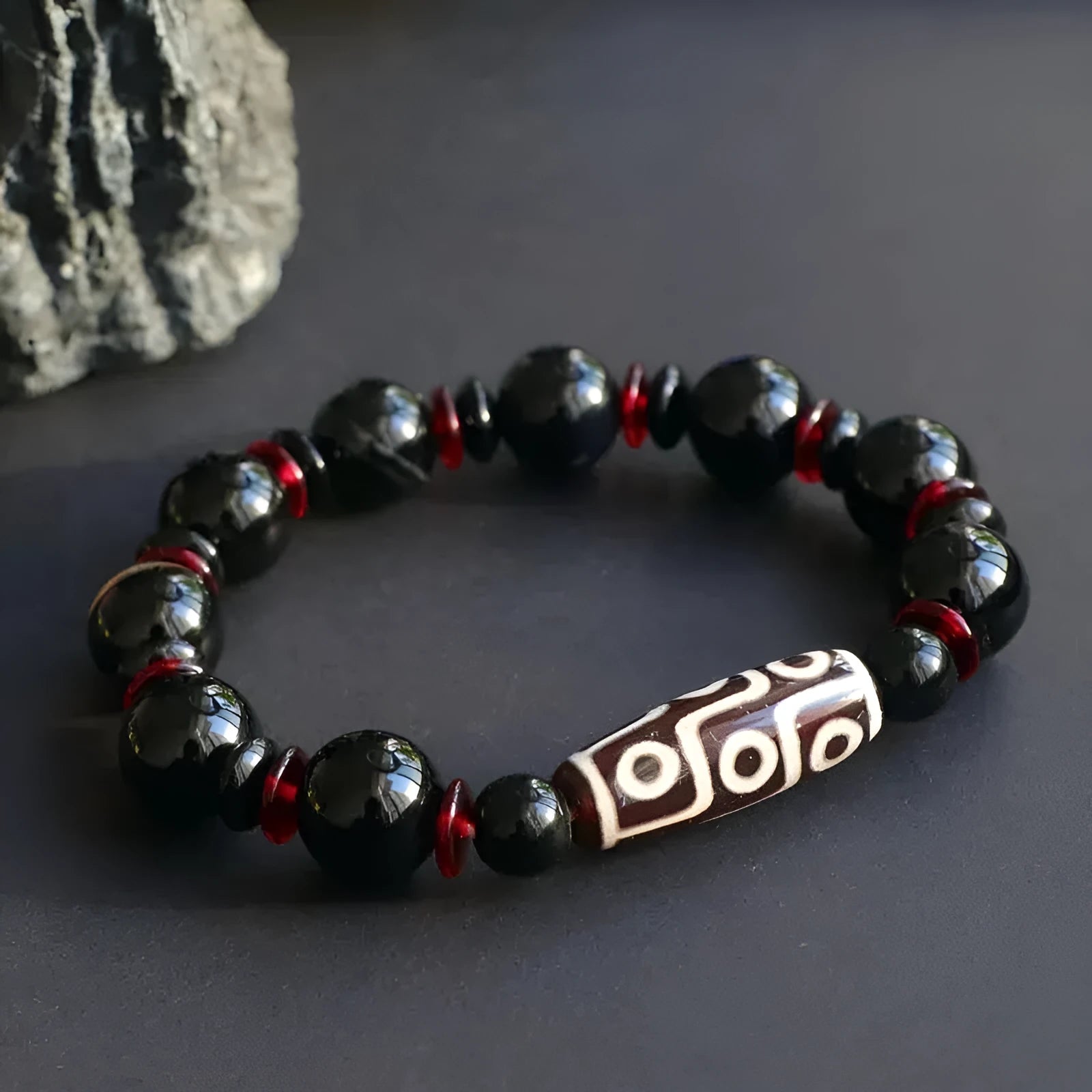 Black agate dzi bead bracelet with hand-woven geometry beads on a wrist.