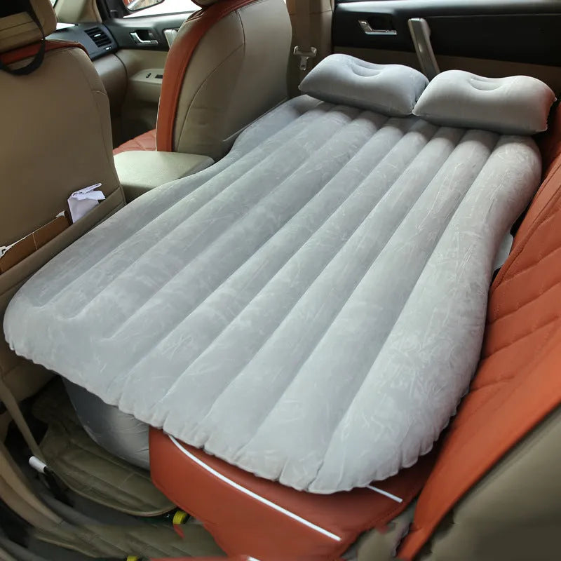 Universal inflatable car air mattress with flocked surface and pillows inside a vehicle.