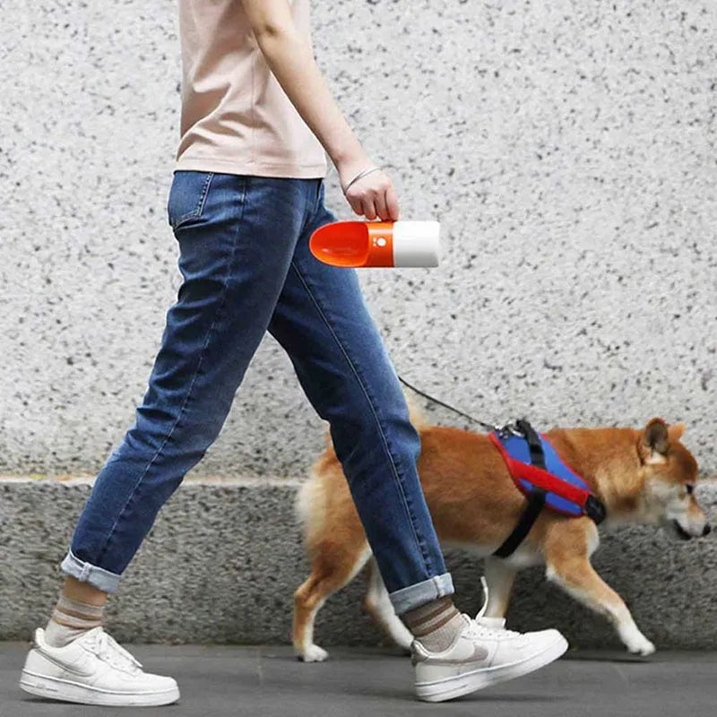 White MOESTAR rocket-shaped pet drinking cup with grey or orange accents showing one-button lock