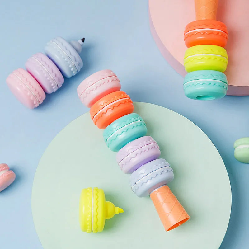 Set of six colourful cookie-shaped highlighter pens with macaron colours arranged on a white surface.