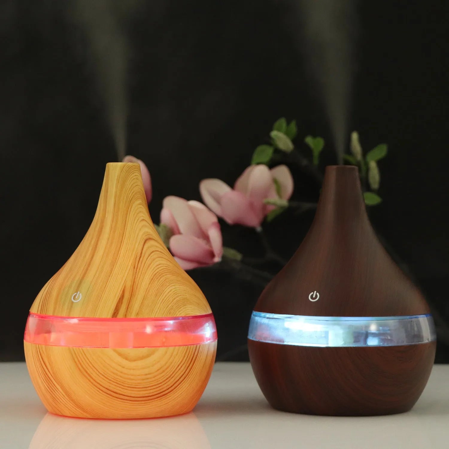 A columnar USB air humidifier with a wood grain finish, remote control, and USB cable on a desktop.
