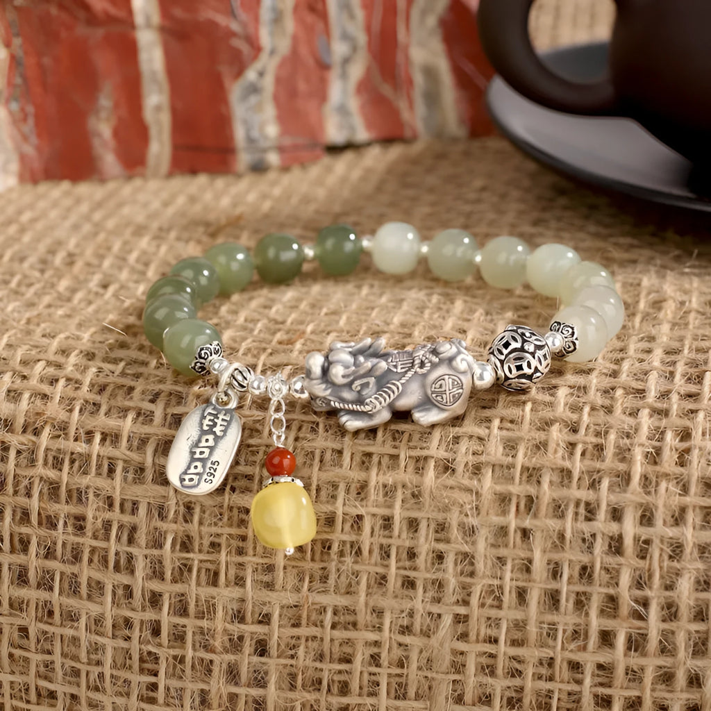 Handmade women's retro bracelet with a natural Hetian jade bead and pure silver coin charm on an adjustable chain.
