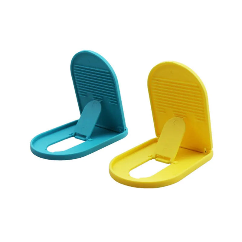 Adjustable plastic mobile phone stand in one of six colour options: black, blue, grey, pink, white, or yellow.