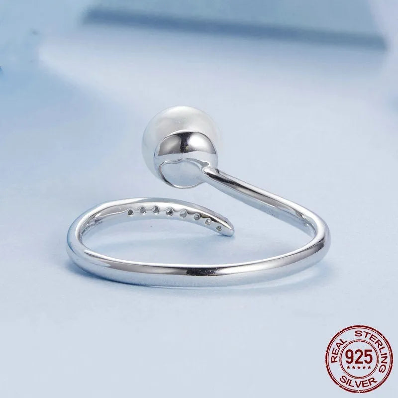 S925 sterling silver adjustable open loop ring with a natural shell pearl on a white background.