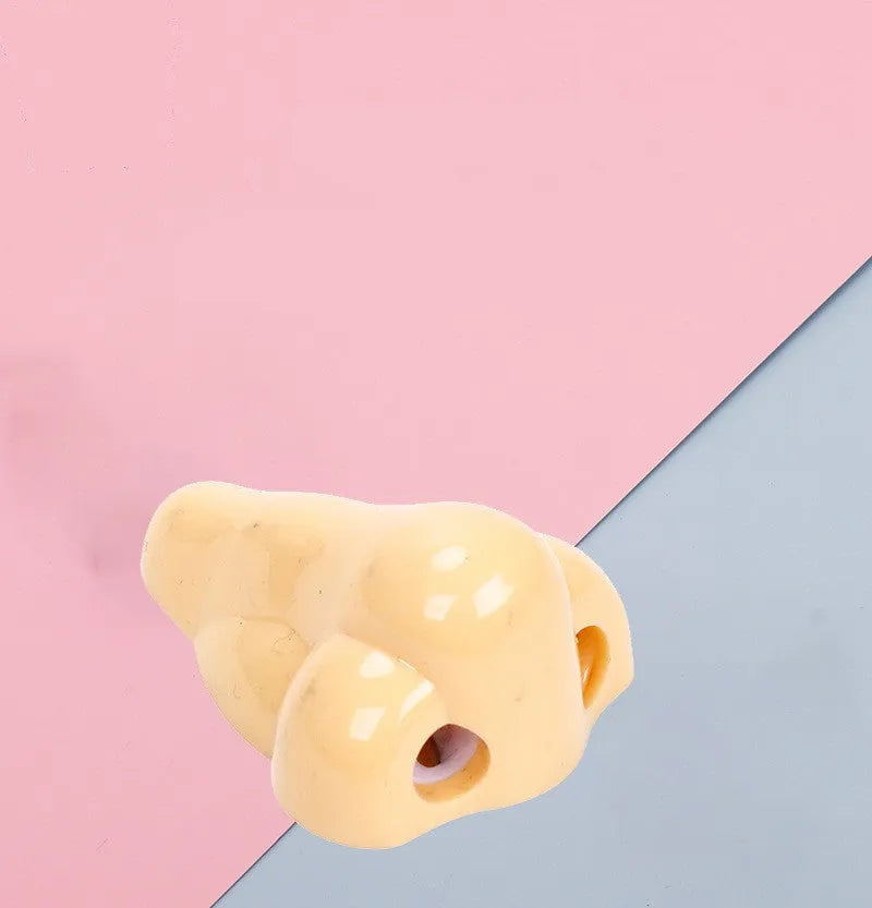 Flesh colour geometric plastic pencil sharpener with large nostril on a white background.