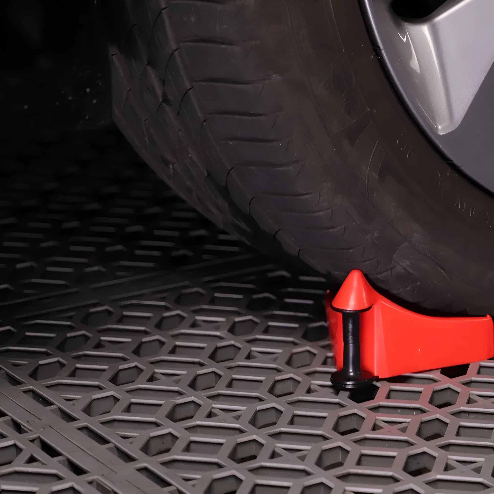 Set of four red plastic and black rubber triangle car parking blocks or wheel stops