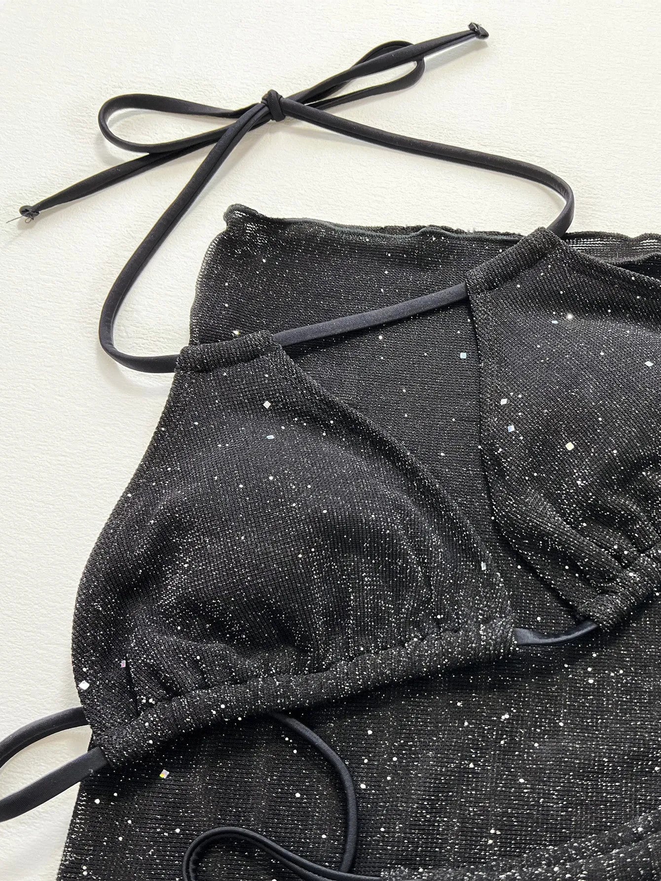 Black three-piece swimsuit bikini set with adjustable top and matching shorts