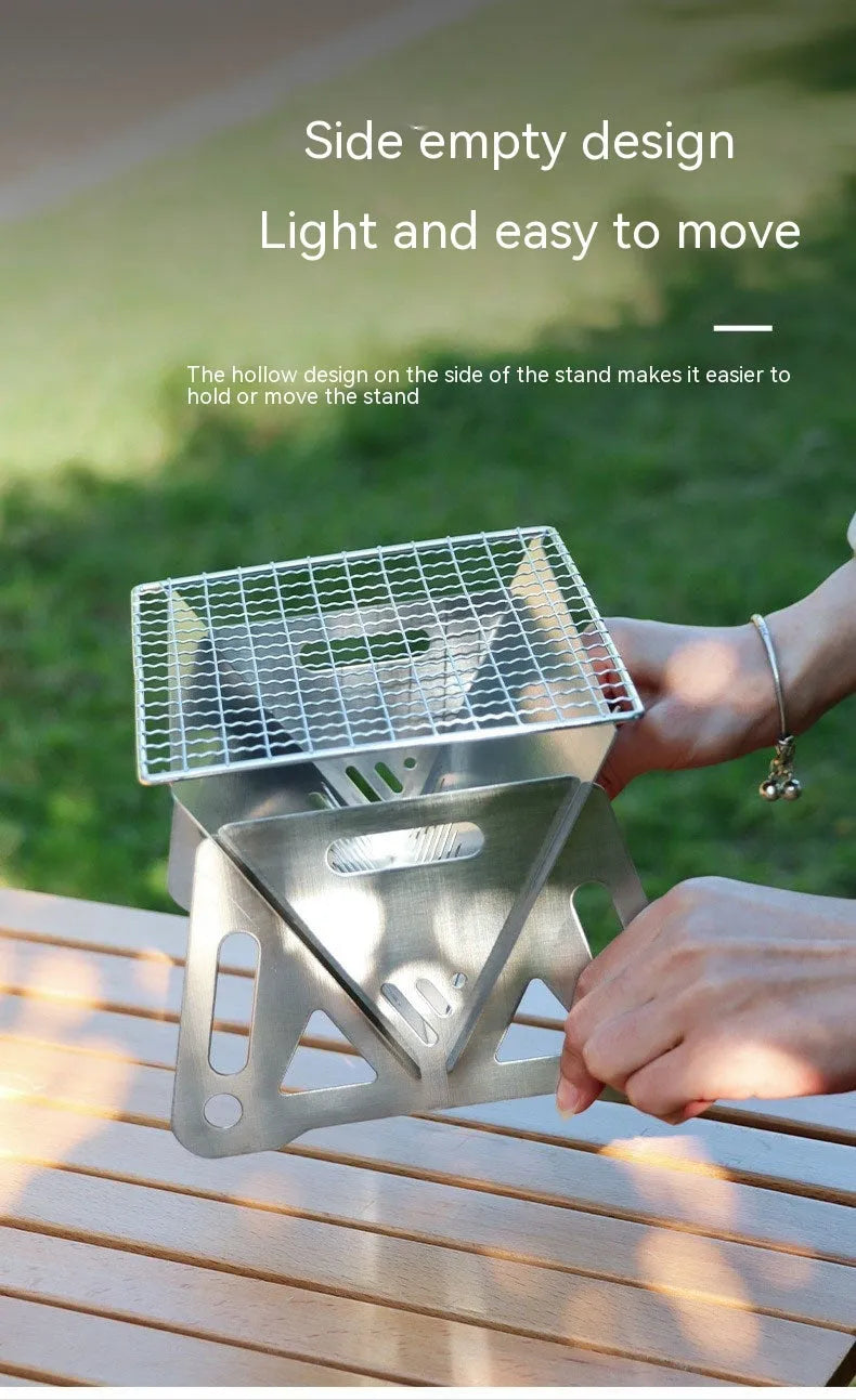 Large foldable stainless steel barbecue oven with storage bag, set up for outdoor use.