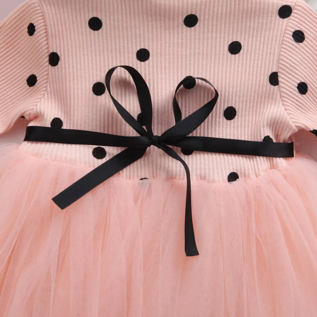 Baby girl in a long sleeve white lace tutu dress for a christening or birthday party.