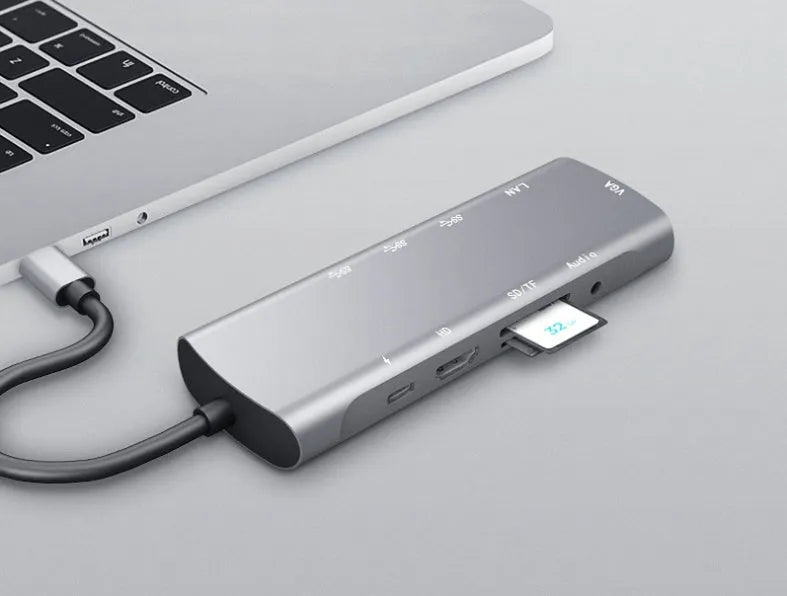 Grey aluminium USB-C docking station with HDMI, VGA, and USB ports.
