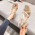 Women's white thick heel slip-on sandals with a chunky high heel and side cutouts on a plain background.