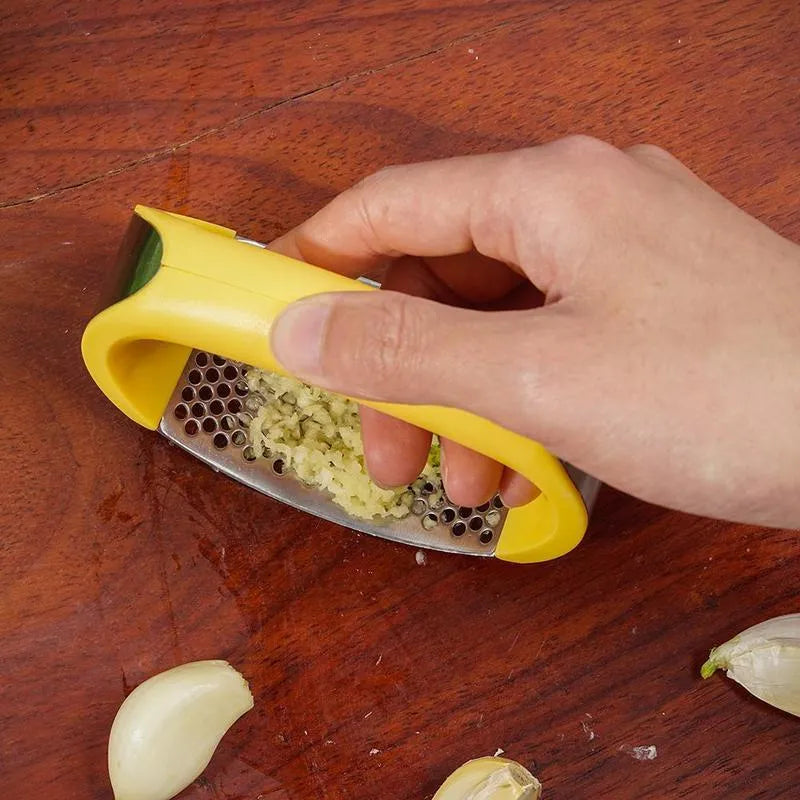 Stainless steel garlic press with non-slip handle in available colours crushing garlic