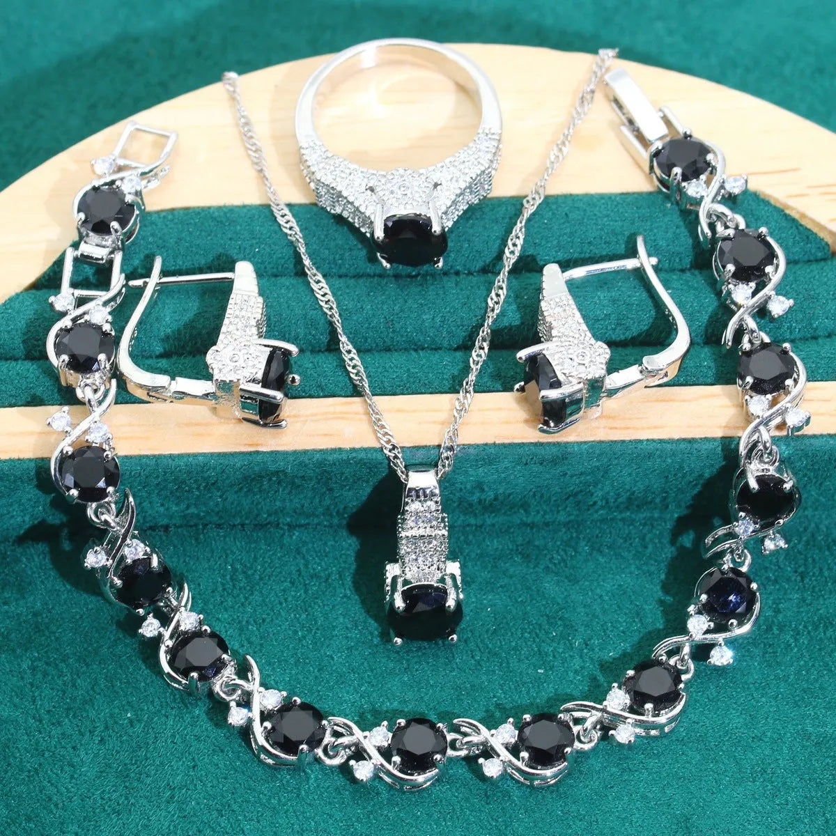 Four-piece bridal zircon jewellery set showing necklace, bracelet, earrings, and ring in a choice of colours.
