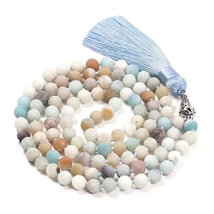 Long blue gemstone tassel necklace with agate, lapis lazuli, and turquoise beads on a geometric pendant.