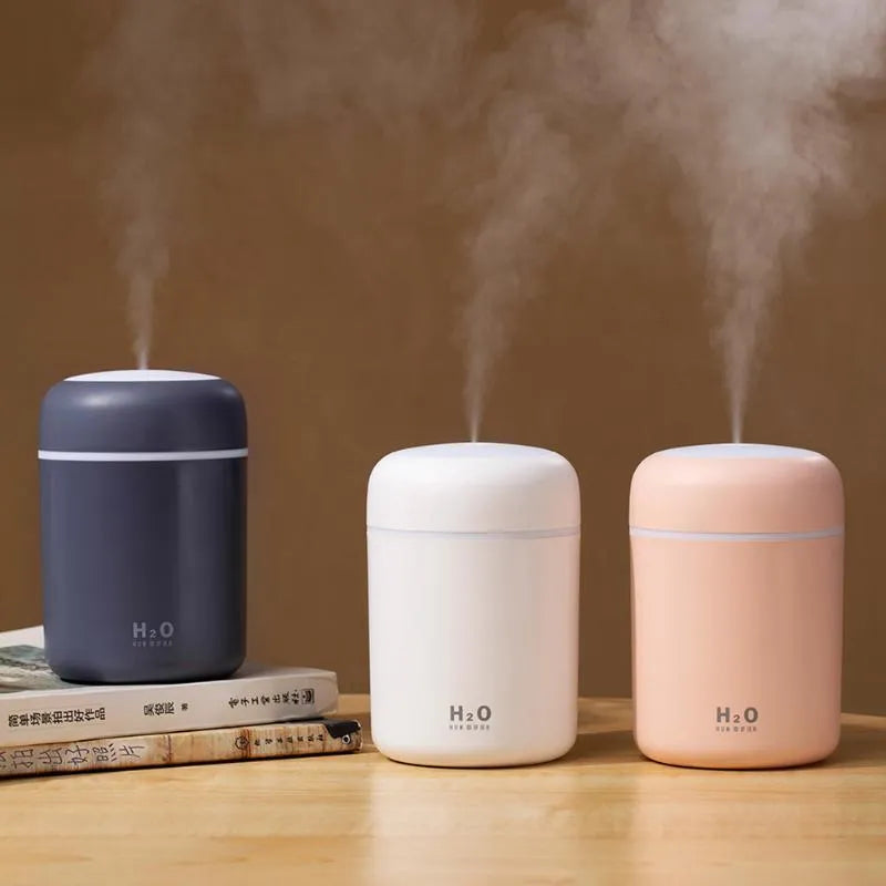 USB desk surface atomiser humidifier with LED lights in pink, white, and navy blue colour options