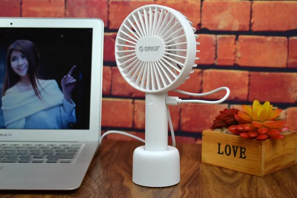 White ORICO FH1 portable USB rechargeable small fan on a desktop.