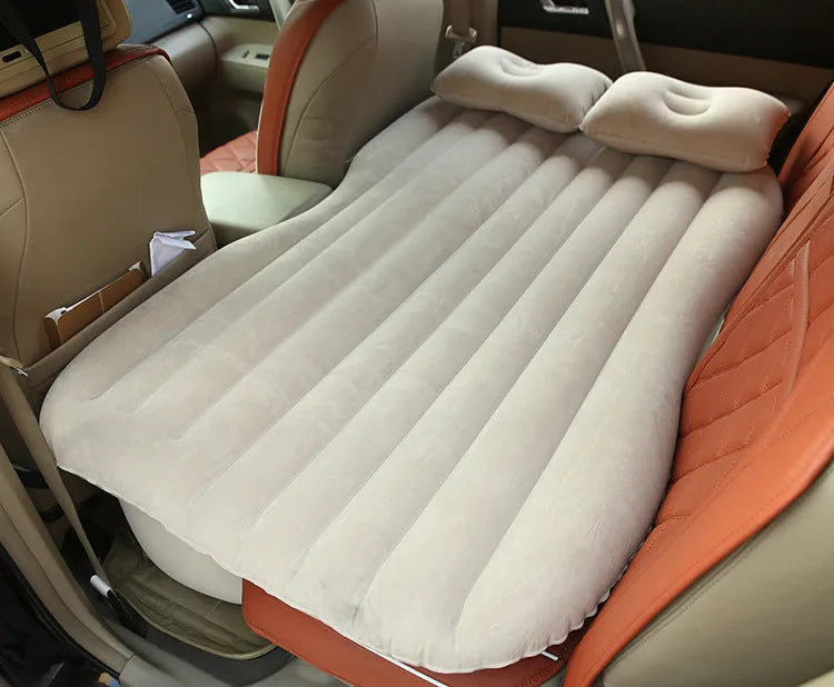 Universal inflatable car bed with flocked cloth, shown with two pillows and a pump.