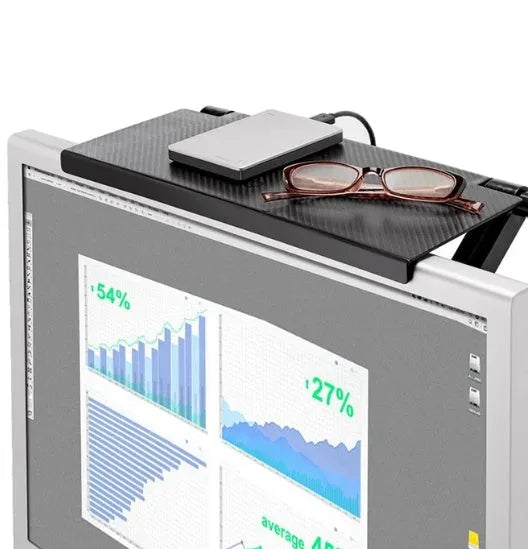 Black adjustable screen top shelf mounted on a monitor holding a streaming device and remote